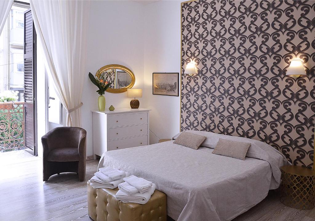 sypialnia z łóżkiem i krzesłem w obiekcie Casa Decò Business Stay Solution w mieście Tarent