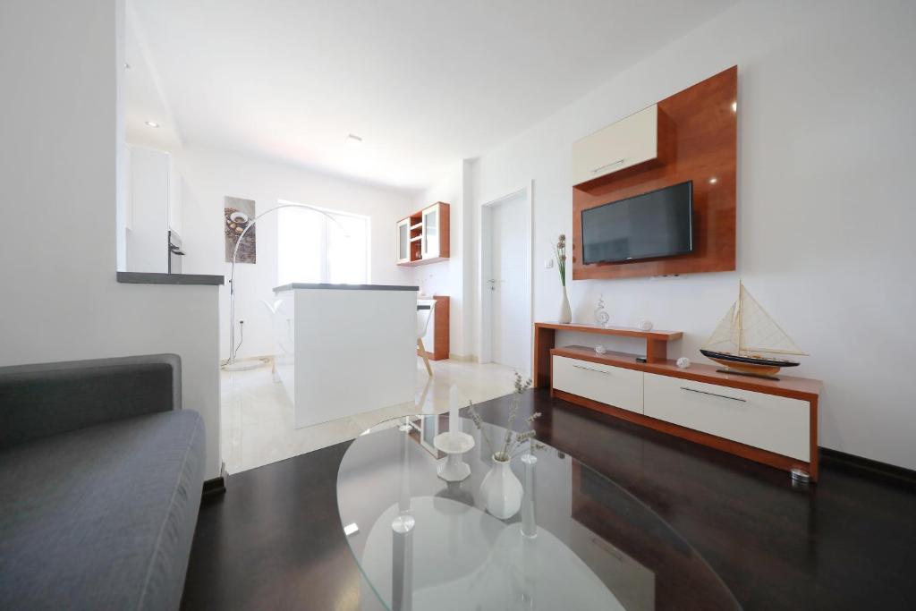 Televízia a/alebo spoločenská miestnosť v ubytovaní Apartmani Postimana
