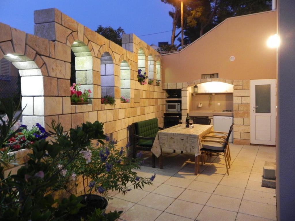 a patio with a table and chairs and a kitchen at Apartments Katarina in Sutivan