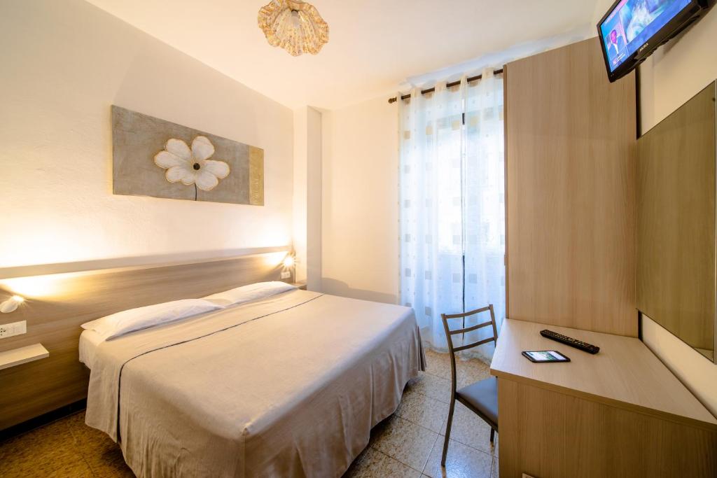 a hotel room with a bed and a desk and a television at La Belle Epoque in Aosta