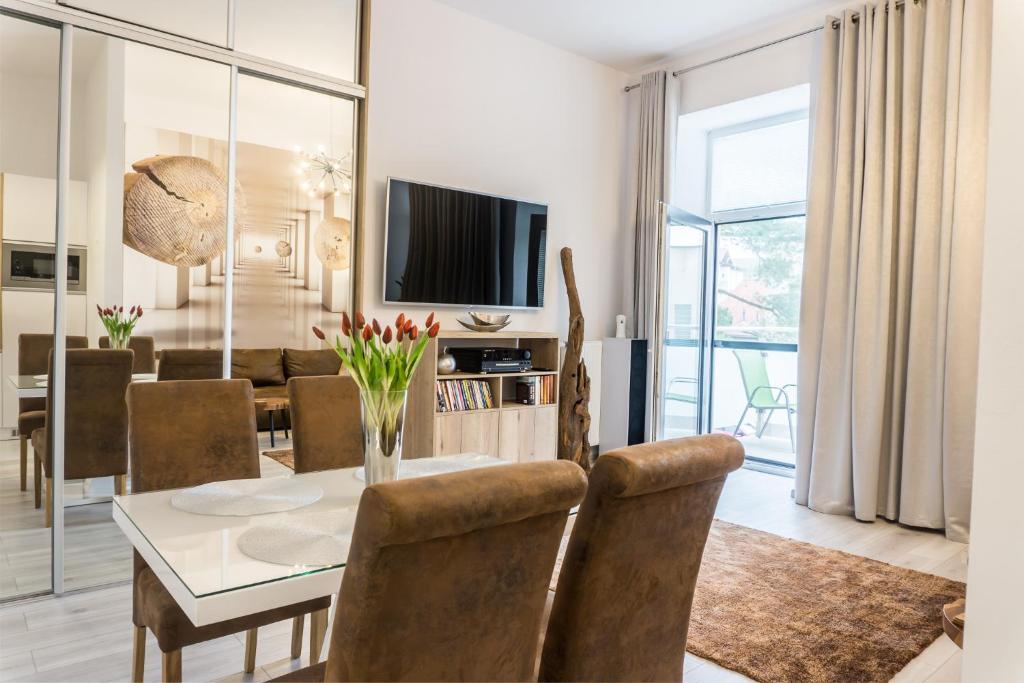 a dining room and living room with a table and chairs at Premium Apartment Centrum in Poprad