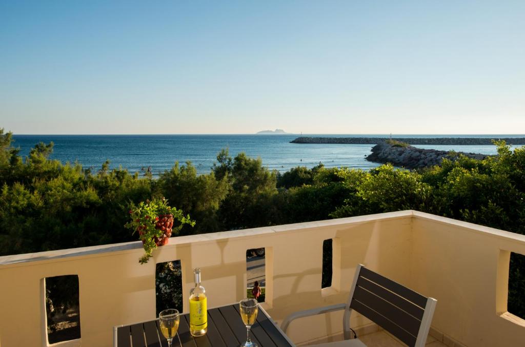 a view of the ocean from the balcony of a house at Golden Sun Apartments in Kokkinos Pirgos