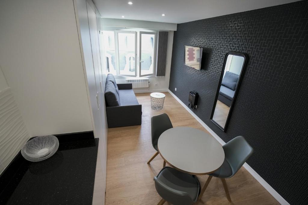 uma sala de estar com uma mesa branca e cadeiras em Bellevue 766 Biarritz em Biarritz