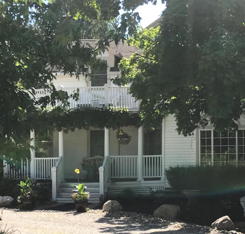 a white house with a porch and a deck at Martha's Vineyard B & B in South Haven