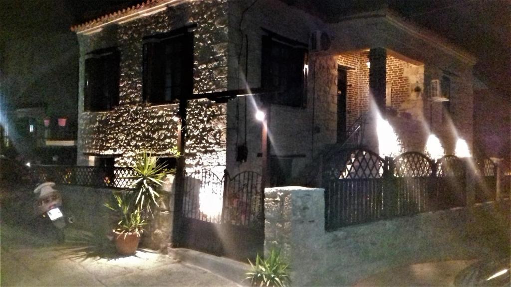 une maison avec une clôture et un portail la nuit dans l'établissement Elisw, à Afytos