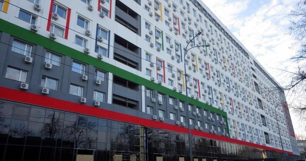 a tall building with a red white and green at Smart-House Smart kvartira s kukhnei vozle metro. in Kyiv