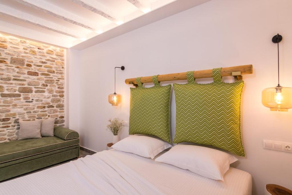 a bedroom with a white bed and a brick wall at Vintage Suites in Limenaria