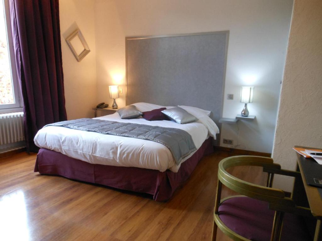 Un pat sau paturi într-o cameră la Logis - Hôtel Restaurant l'Ecu de France