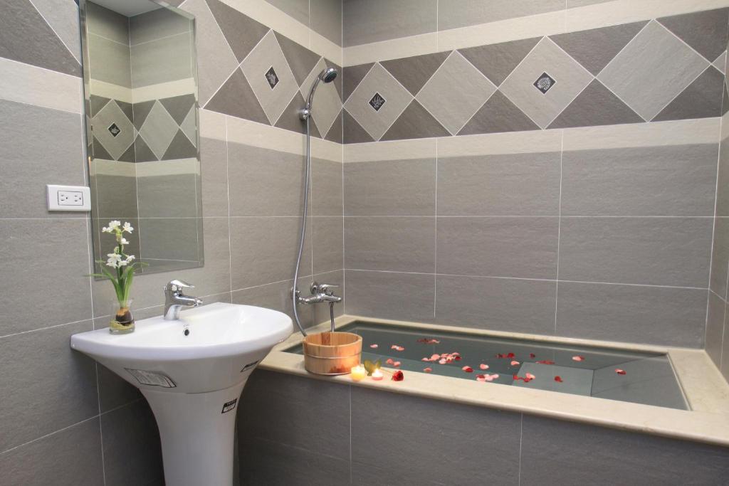 a bathroom with a sink and a bath tub at Spring Fountain Hotel in Jiaoxi