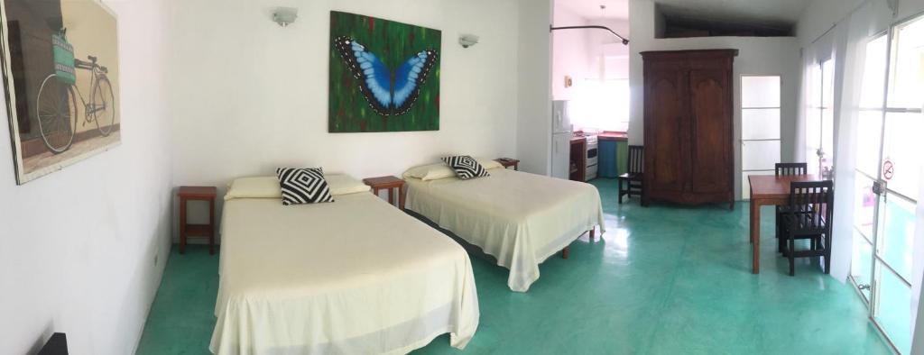 a room with two beds and a table and chairs at Casa de la Luz - Studio Apartment in Tlacotalpan
