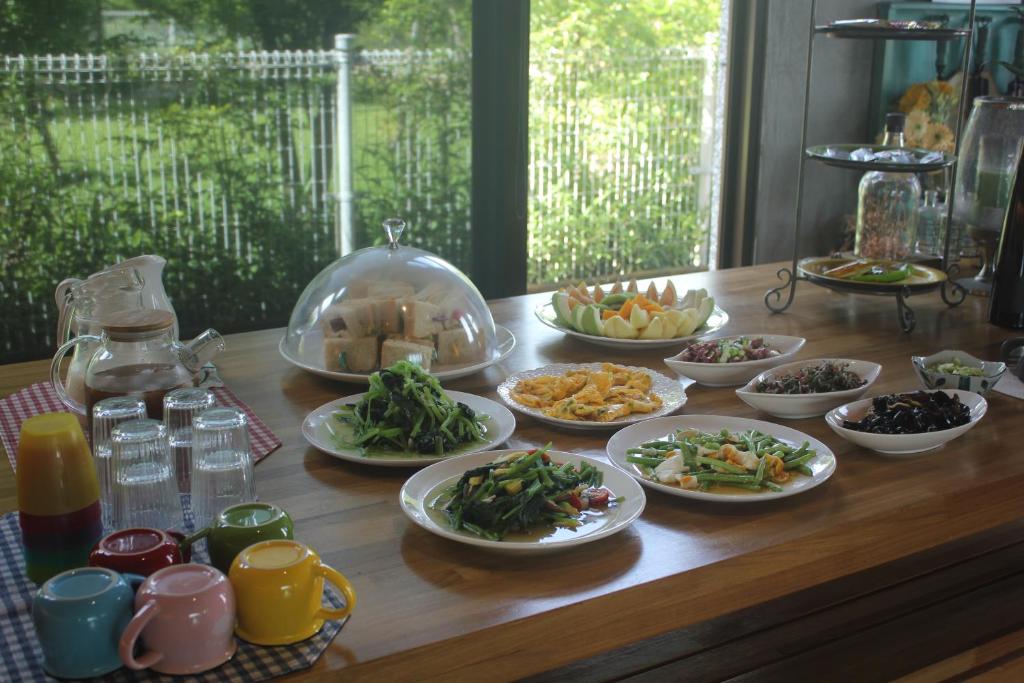 a wooden table with plates of food on it at Muho B&amp;B in Dongshan