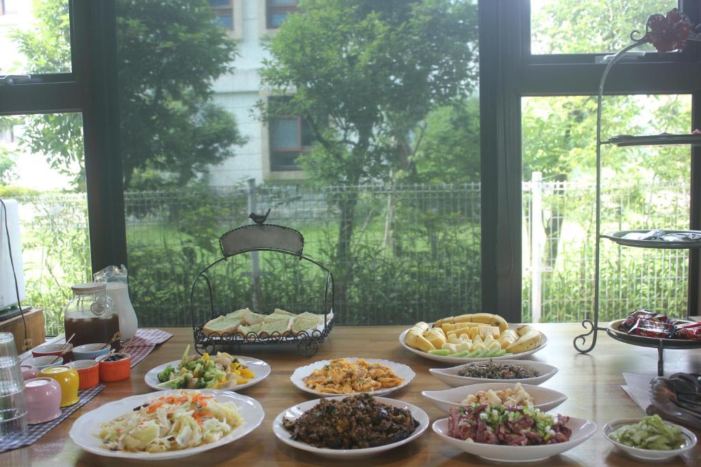 a table with many plates of food on it at Muho B&amp;B in Dongshan