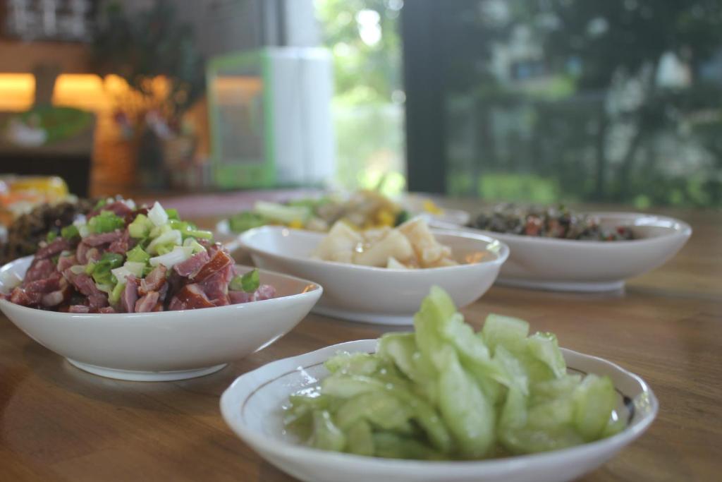 four bowls of food on a wooden table at Muho B&amp;B in Dongshan