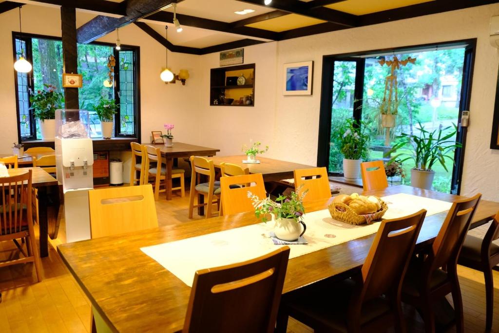een eetkamer met een houten tafel en stoelen bij Pension Nugget Inn in Hakuba