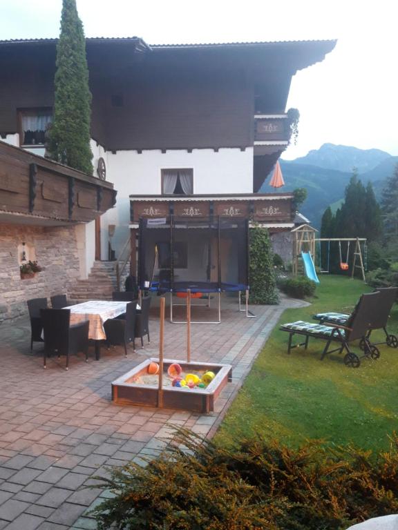 a patio of a house with a table and chairs at Pension Chalet Bergseegut in Wagrain