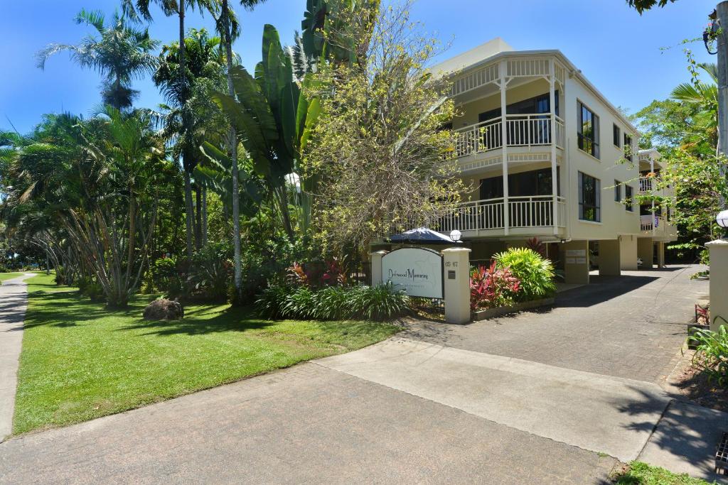 a large yellow house with palm trees and a driveway at Seascape Holidays - Driftwood Mantaray in Port Douglas