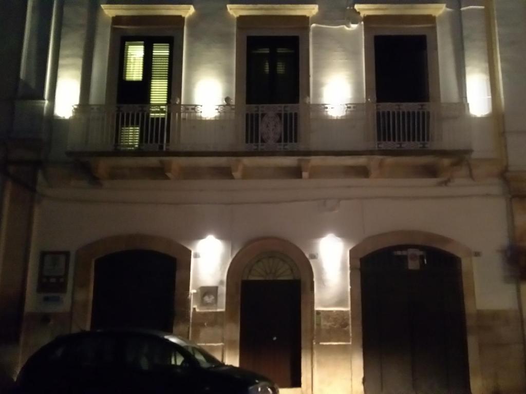 a building with a balcony and a car parked in front at Tenuta il Bosco con parcheggio in Bitonto