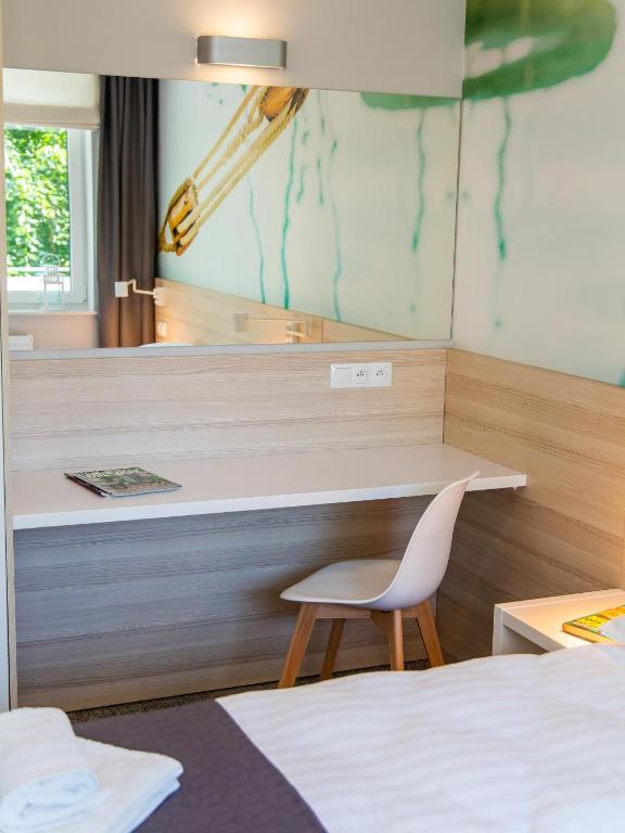 a room with a desk and a chair and a mirror at Apartamenty Baltia Kołobrzeg - Bliżej Morza in Kołobrzeg
