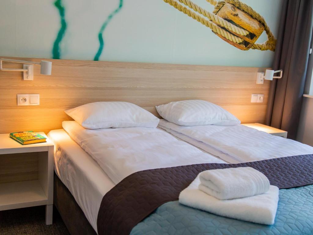 a bedroom with a bed with two pillows on it at Apartamenty Baltia Kołobrzeg - Bliżej Morza in Kołobrzeg