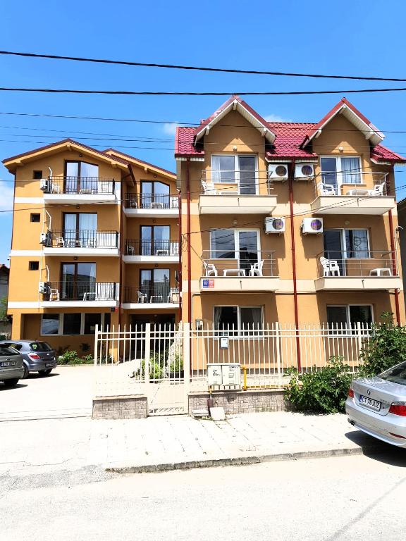 a large apartment building with a fence in front of it at Vilele Liliana in Mamaia Sat/Năvodari