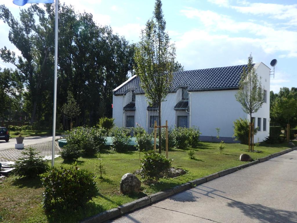 ein weißes Haus mit einem Garten davor in der Unterkunft Zur Saale in Weißenfels