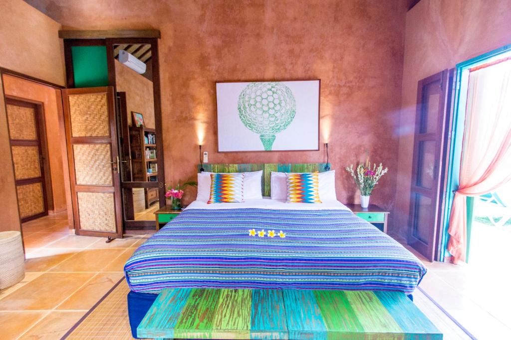 - une chambre avec un grand lit et des oreillers colorés dans l'établissement Villa Jeruk II 2 Bedrooms Umalas Canggu, à Canggu