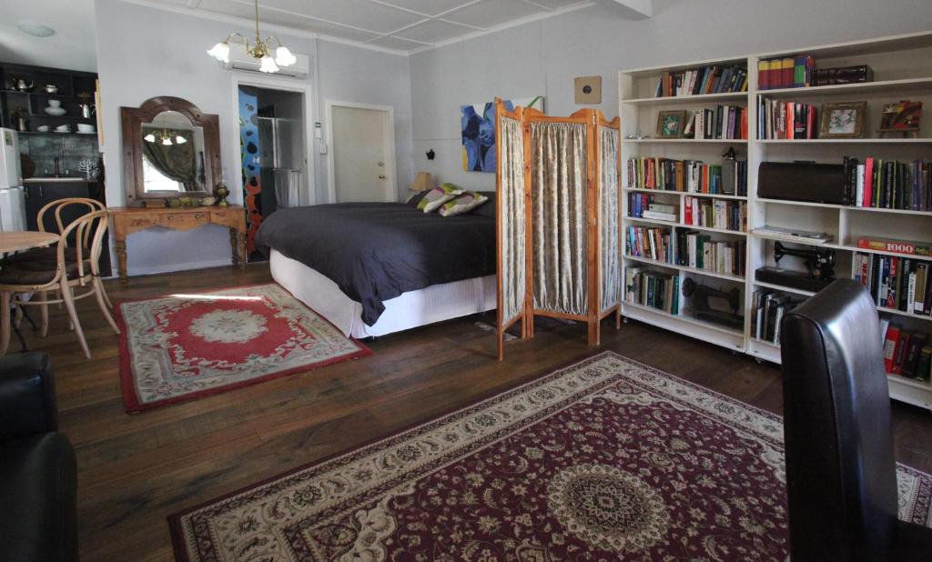 a bedroom with a bed and book shelves with books at Wallace Lodge - PID-STRA-16871 in Braidwood