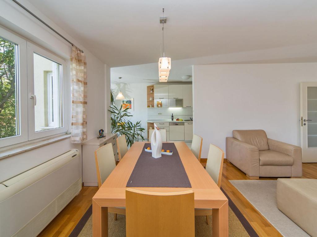 a living room with a dining room table with chairs at Spacious apartment in Dubrovnik with private garage in Dubrovnik