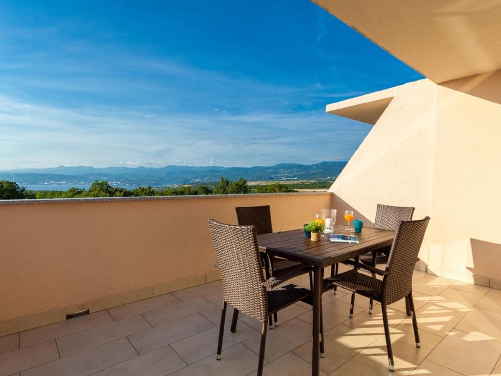 una mesa y sillas en un balcón con vistas en Lush Apartment in Omi alj near Seabeach, en Omišalj
