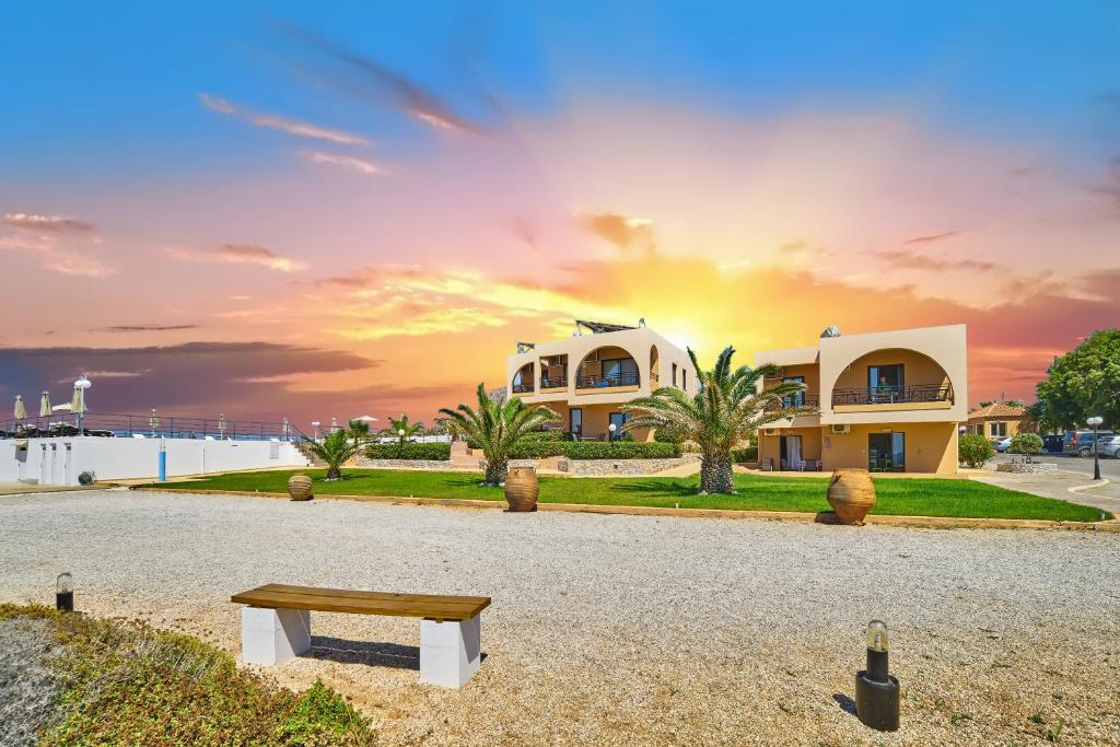 a house on the beach with a bench in front of it at Nanakis Beach Apartments in Stavros