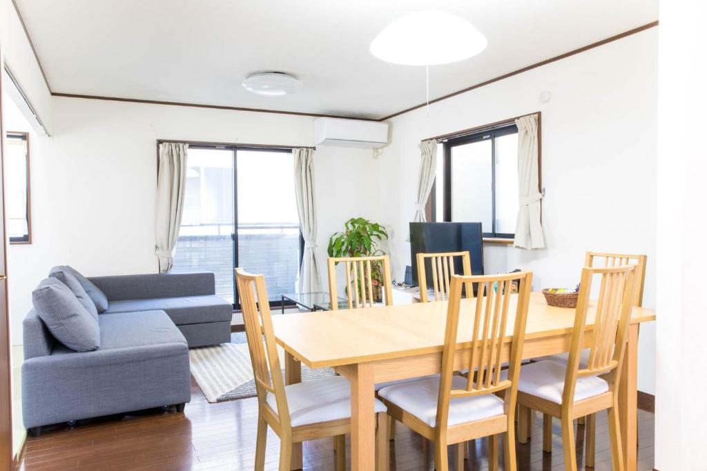 uma sala de jantar e sala de estar com mesa e cadeiras em Tokyo Aoto House em Tóquio