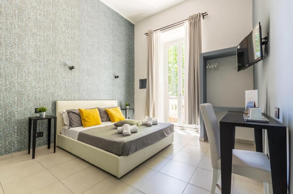 羅馬的住宿－Merulana 139 Suites，一间卧室配有一张带黄色枕头的床和一张书桌