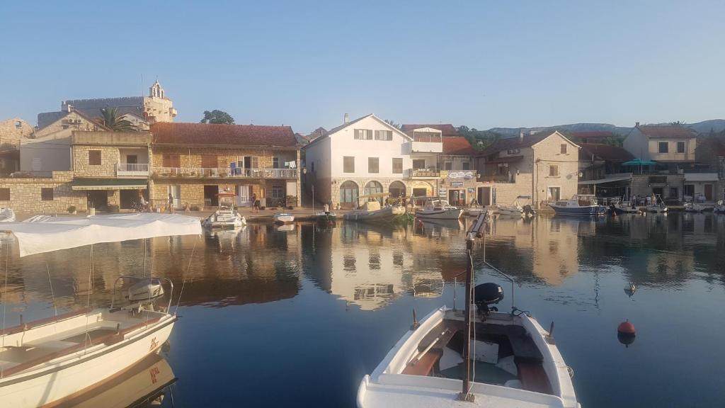 a boat is docked in a harbor with buildings at Apartments Damjanic Jerko in Vrboska