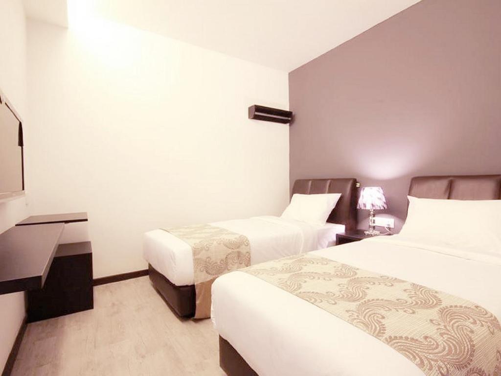 Postel nebo postele na pokoji v ubytování Sandy Hotel Malacca