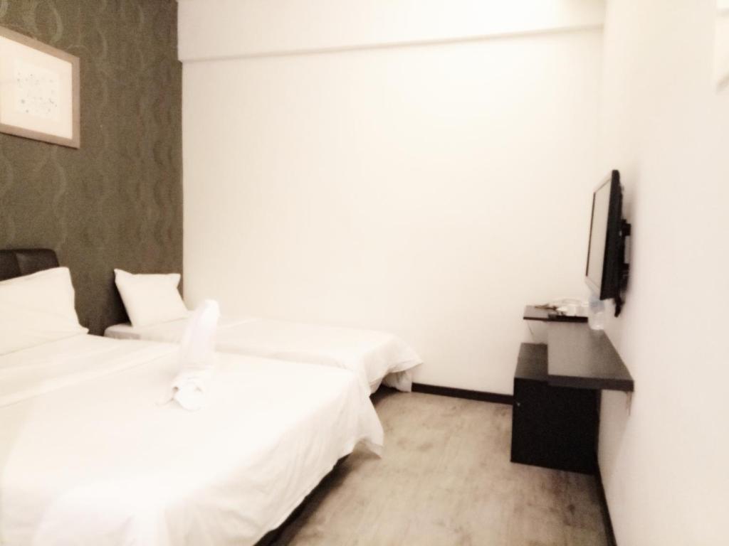 Postel nebo postele na pokoji v ubytování Sandy Hotel Malacca