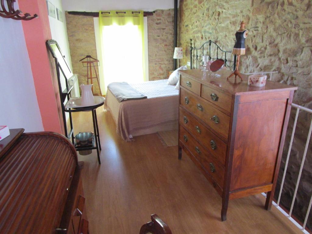 a bedroom with a bed and a dresser in a room at Ca'ls avis in Serra