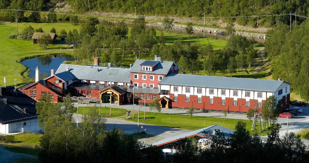 an aerial view of a large building with a river at Ramundbergets Fjällgård in Ramundberget