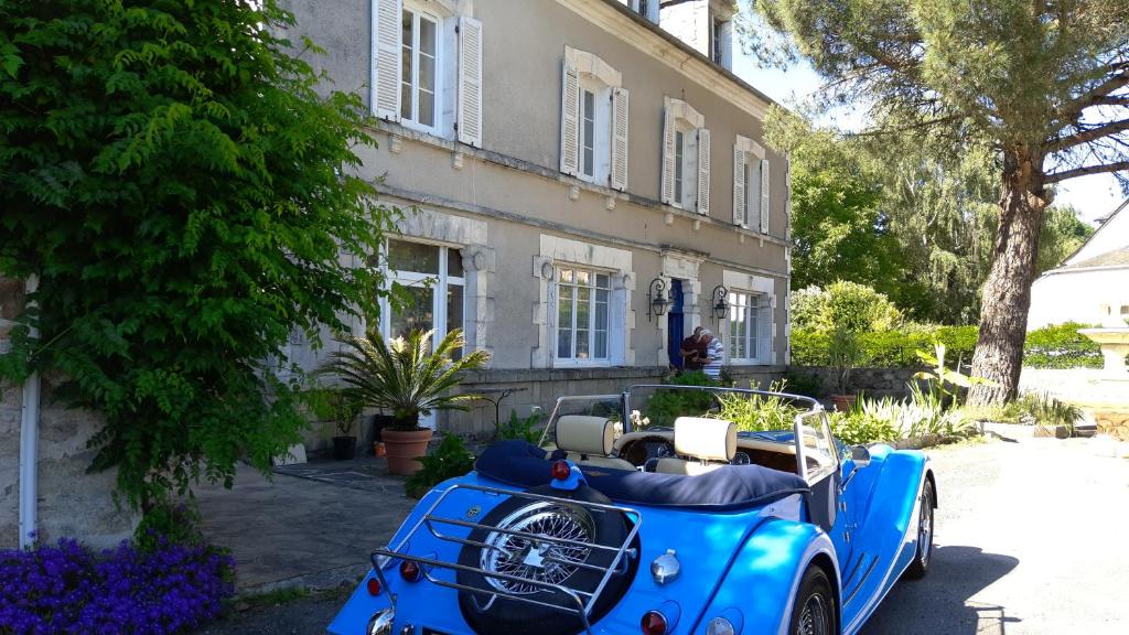 une voiture bleue garée devant un bâtiment dans l'établissement La Morgiane, à Saint-Germain-les-Vergnes