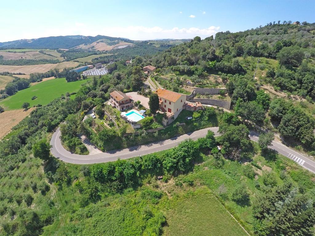 San Dalmazio的住宿－Agriturismo Le Capanne，享有山丘上房屋空中景观和道路