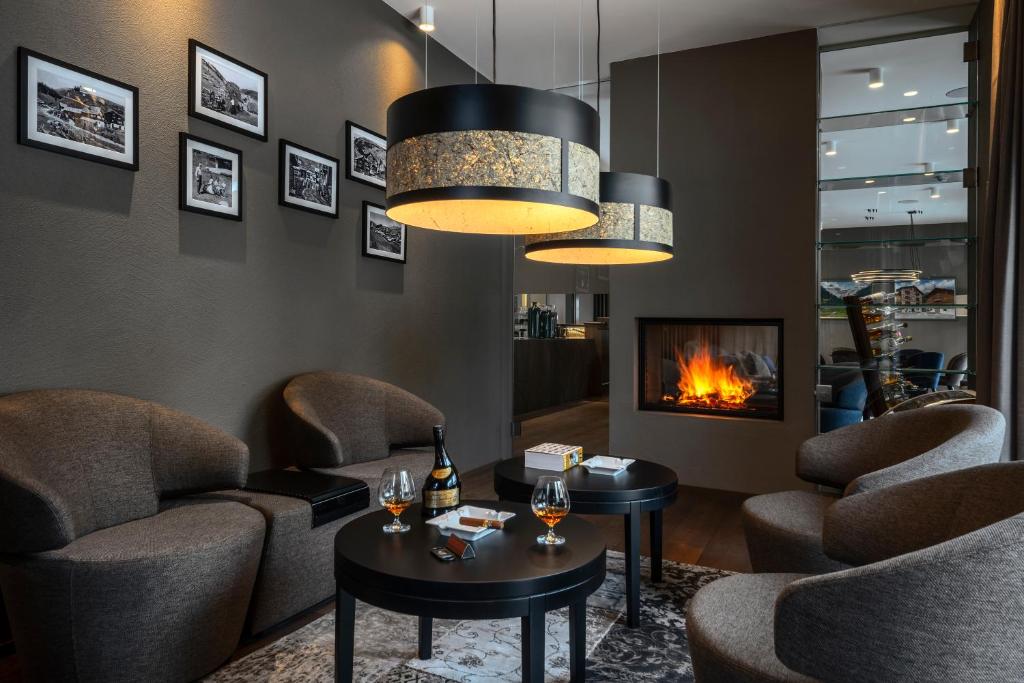 a waiting room with chairs and a fireplace at Hotel Mischun in Breil/Brigels