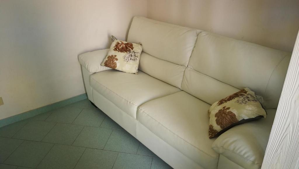 un divano bianco con due cuscini sopra di VisitPonza - Trilocale sul corso a Ponza