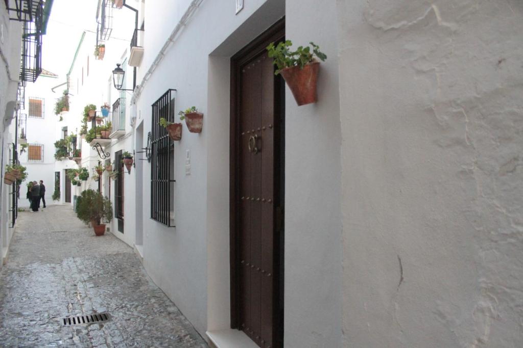 an empty alley with a door and potted plants at Casa Rural Azahar in Priego de Córdoba
