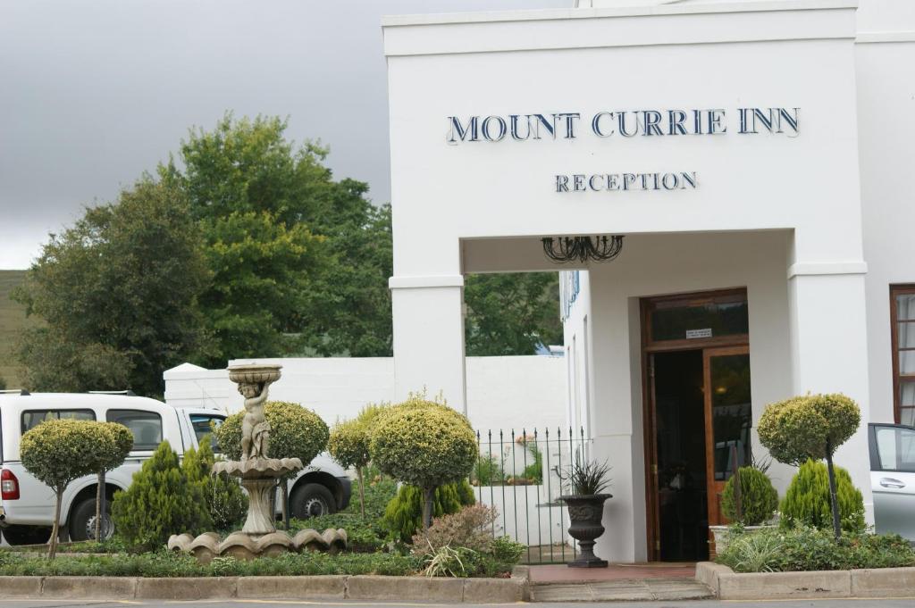 Mount Currie Inn في كوكستاد: مبنى به لافتة تنص على نزل جبل خرسانية