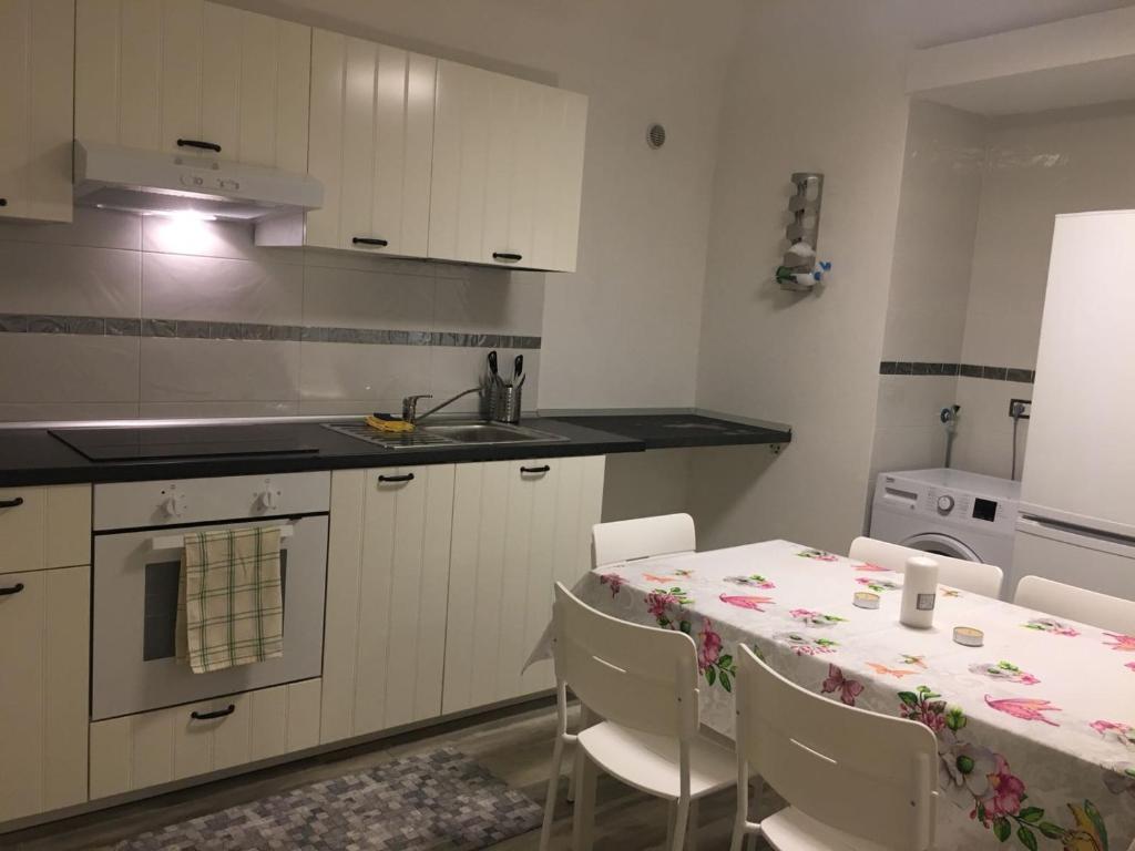kuchnia ze stołem, krzesłami i zlewem w obiekcie Home sweet home Vietri w mieście Vietri sul Mare