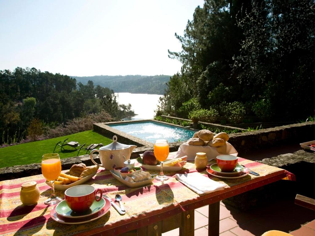 tavolo da picnic con cibo e bevande e piscina di Quinta do Troviscal a Castelo de Bode
