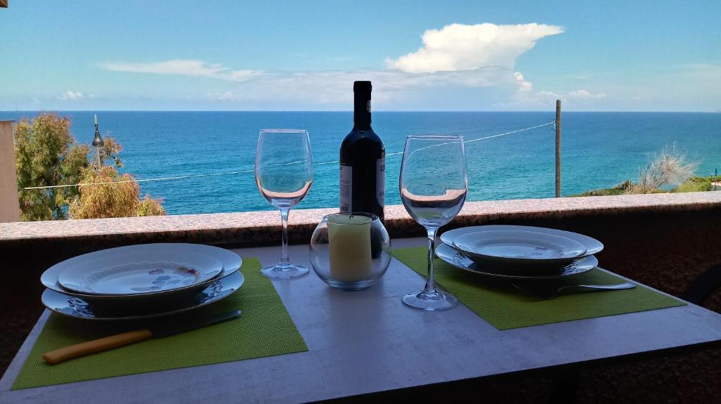 a table with a bottle of wine and two glasses at La Petronilla in Castelsardo