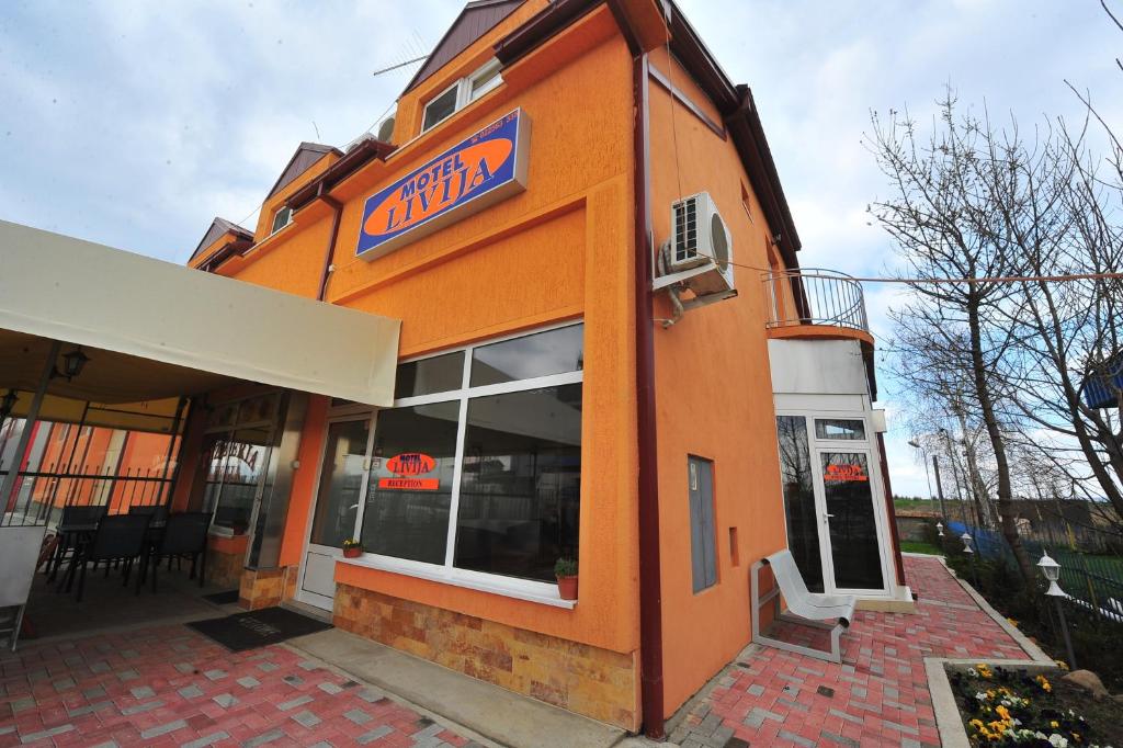 un edificio naranja con un letrero. en Motel Livija, en Petrovec