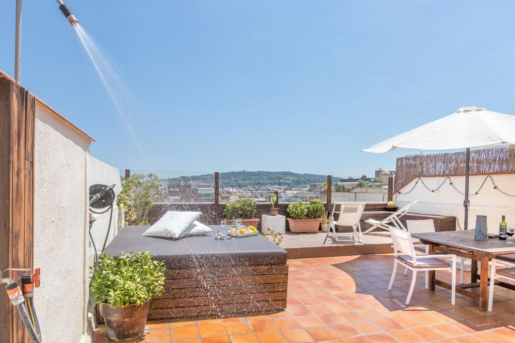 a patio with a table and chairs and an umbrella at Atic Barcelona in Barcelona