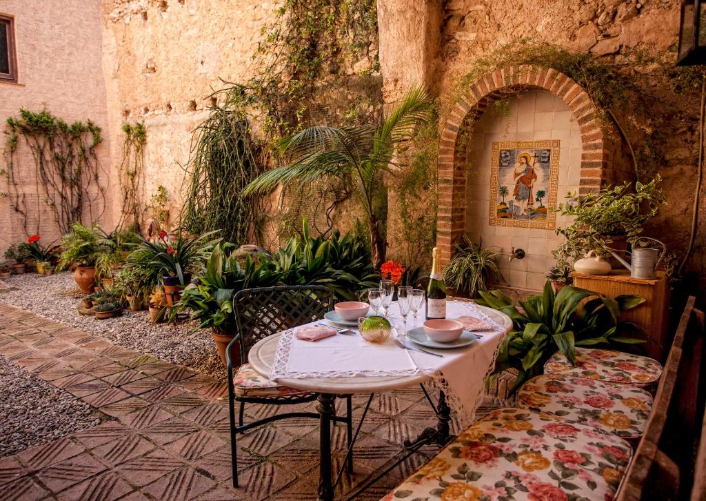 una mesa y sillas en un patio con plantas en Cal Calaf, en Vilardida