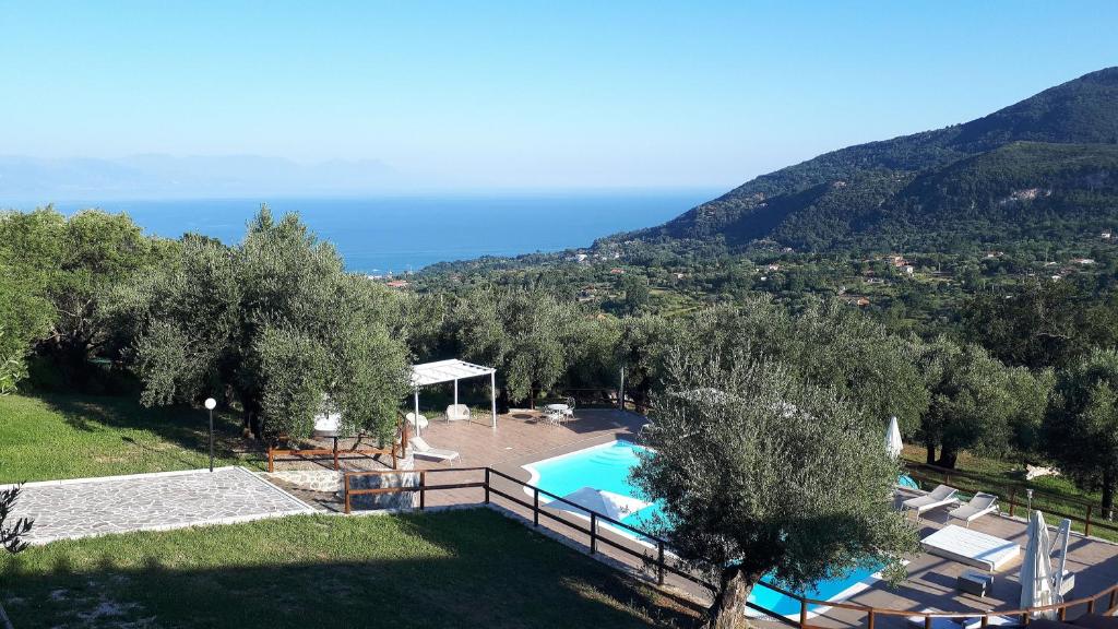 an aerial view of a swimming pool with trees and the ocean at Tenuta Terre di Bosco in San Giovanni a Piro